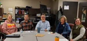 Three people sitting at a table with drinks.