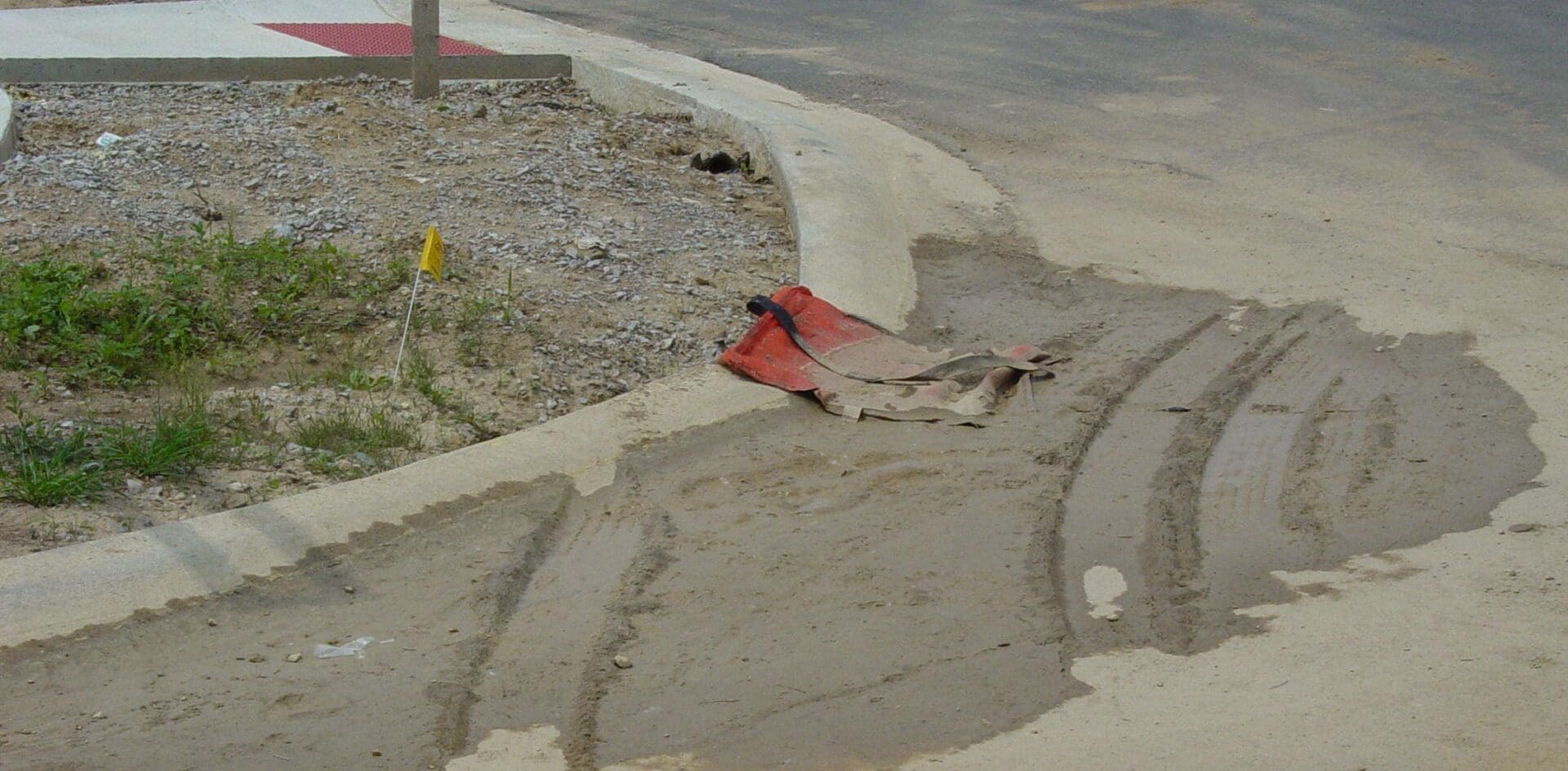 A red fire hydrant laying on the side of a road.